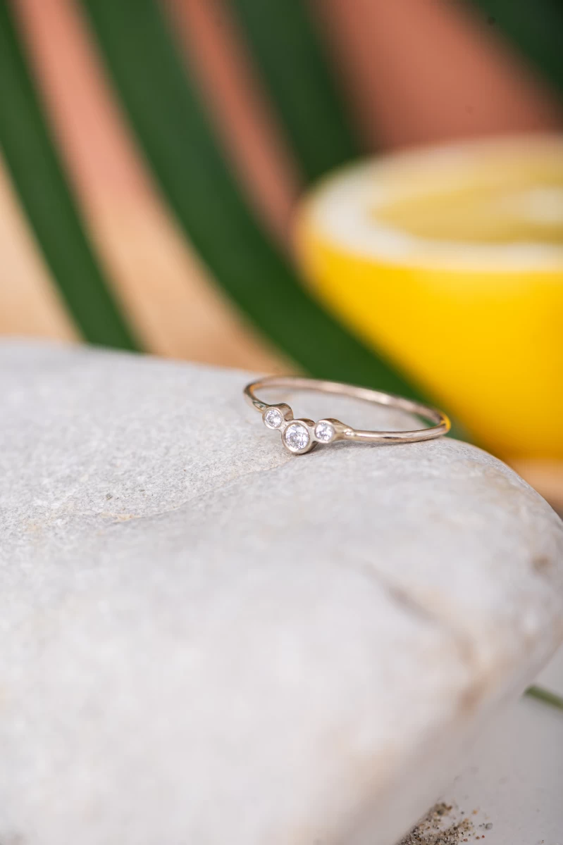 Rožnatozlat 14K prstan z ukrivljeno linijo poldragih kamnov iz cirkonije